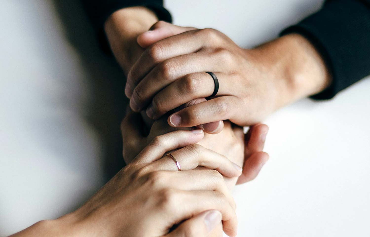 Friends holding hands in show of support.