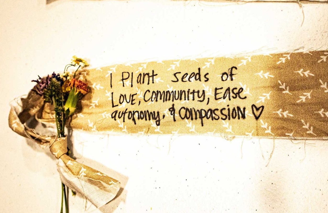 Artwork showing, "plant the seeds of love, community, ease autonomy and compassion."